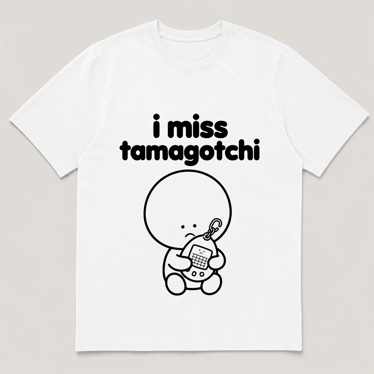 lonely boi tee: a small sad cartoon boy hugging an egg-shaped virtual pet keychain, with the words i miss tamagotchi above him