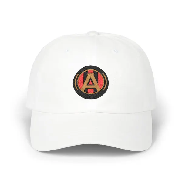Abstract geometric embroidery in black, old gold, and red on a beige cotton cap.